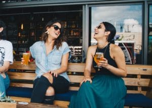 Two women laughing outside of restaurant